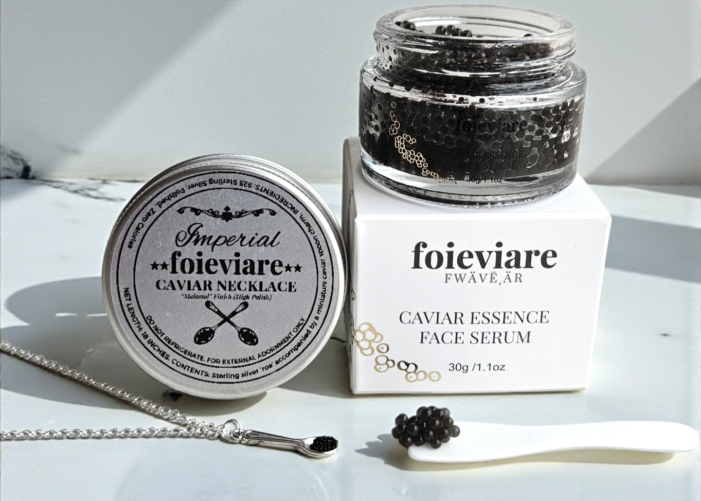 Foieviare caviar essence face serum jar and packaging on a marble surface